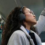 Kvinna på tunnelbana med hörlurar på sig
