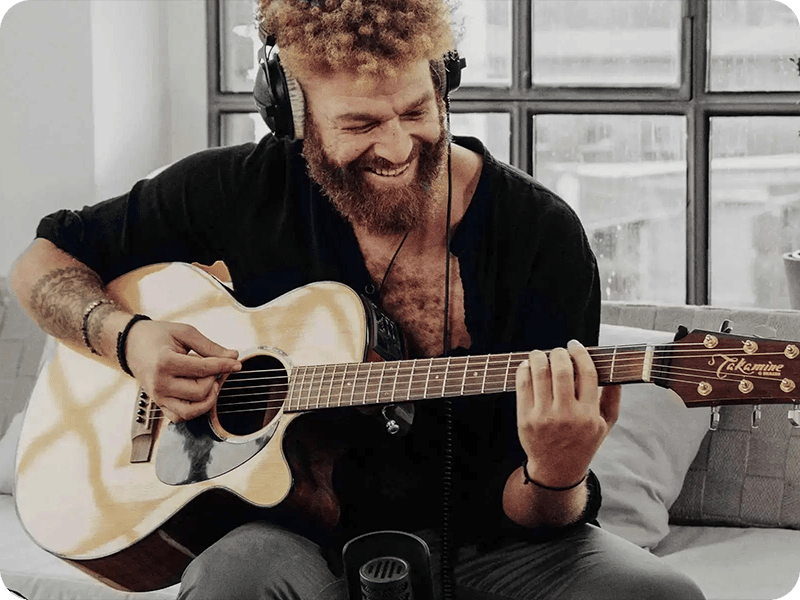 Man med hörlurar som spelar gitarr
