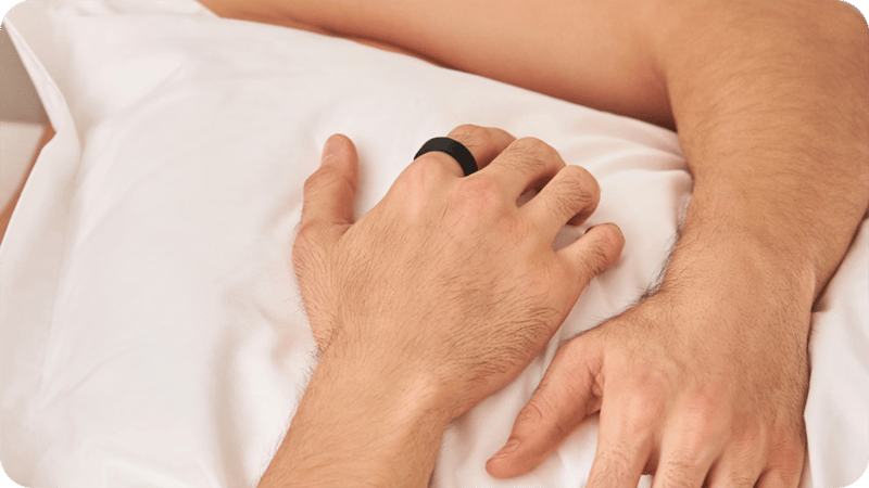 Händer med en ring på fingret, kramandes en kudde