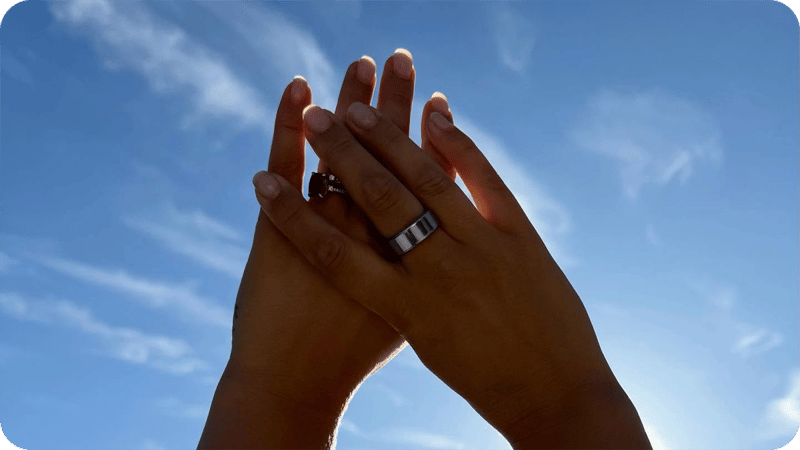Två händer mot himlen med varsin ring
