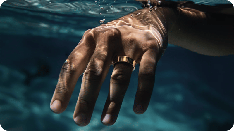 En hand under vattnet med en ring på fingret