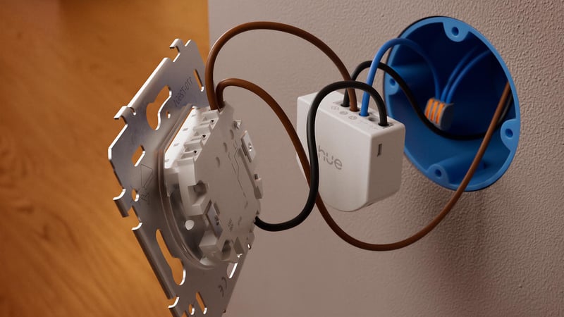 Inzommad bild bakom den vita strömbrytaren med hue relay module