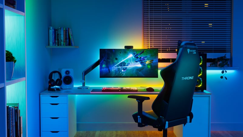 Skrivbord med gamingdator och färglada ljusslingor