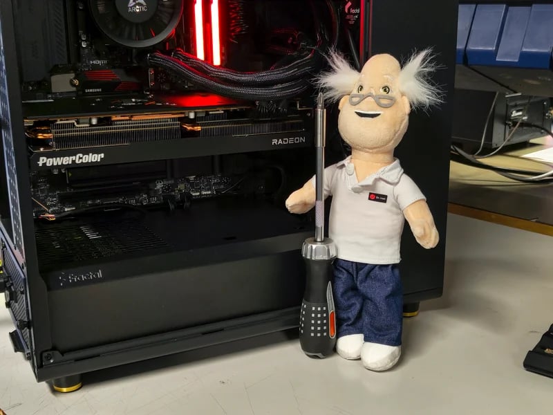 Dr Inet Plushie med en skruvmejsel vid en dator