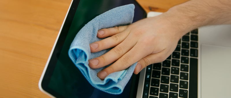 Hand som torkar av en skärm
